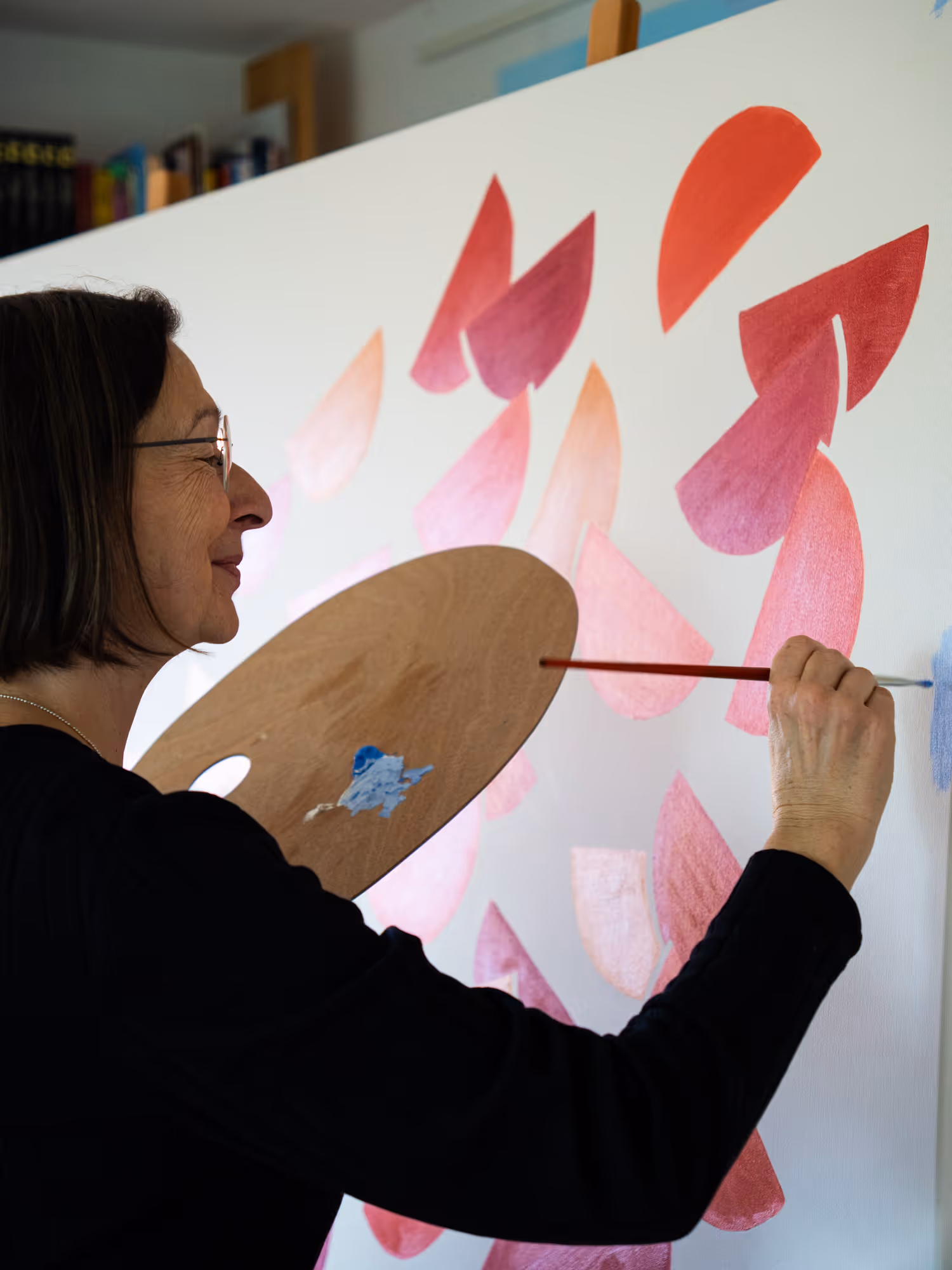 Gabriele Rösel, wie sie mit Pinsel und Malerpalette an einem Werk arbeitet